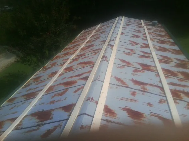 Rusted metal roof panels with new wood purlins before replacement — Storm Damage Roof Repair in Wilburton by Roofing Brothers