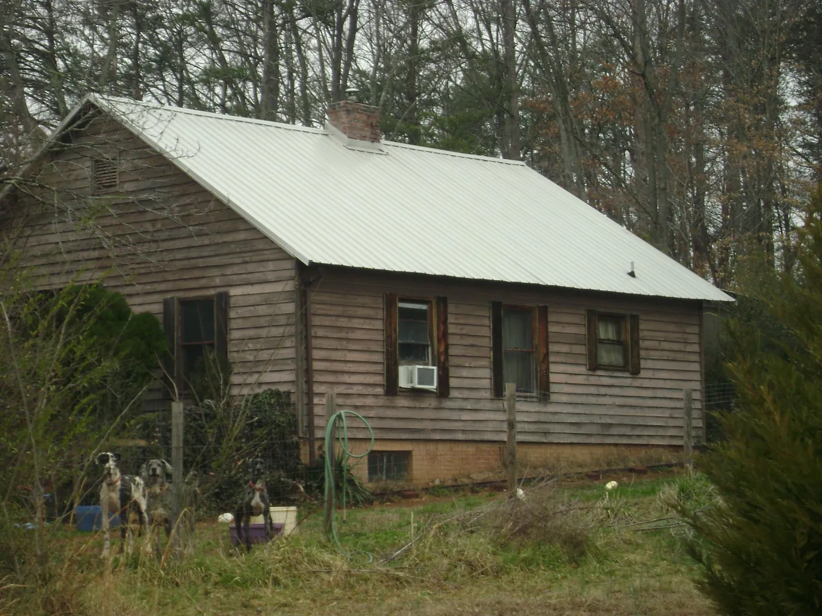 White metal roof on an old wood sided farmhouse, from a Metal Roof Installation job in Wilburton